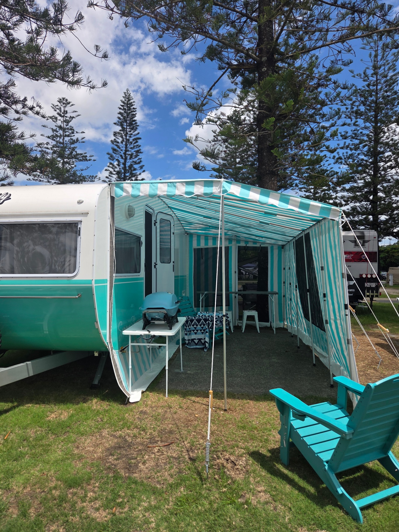 Retro caravan with striped awning and outdoor setup
